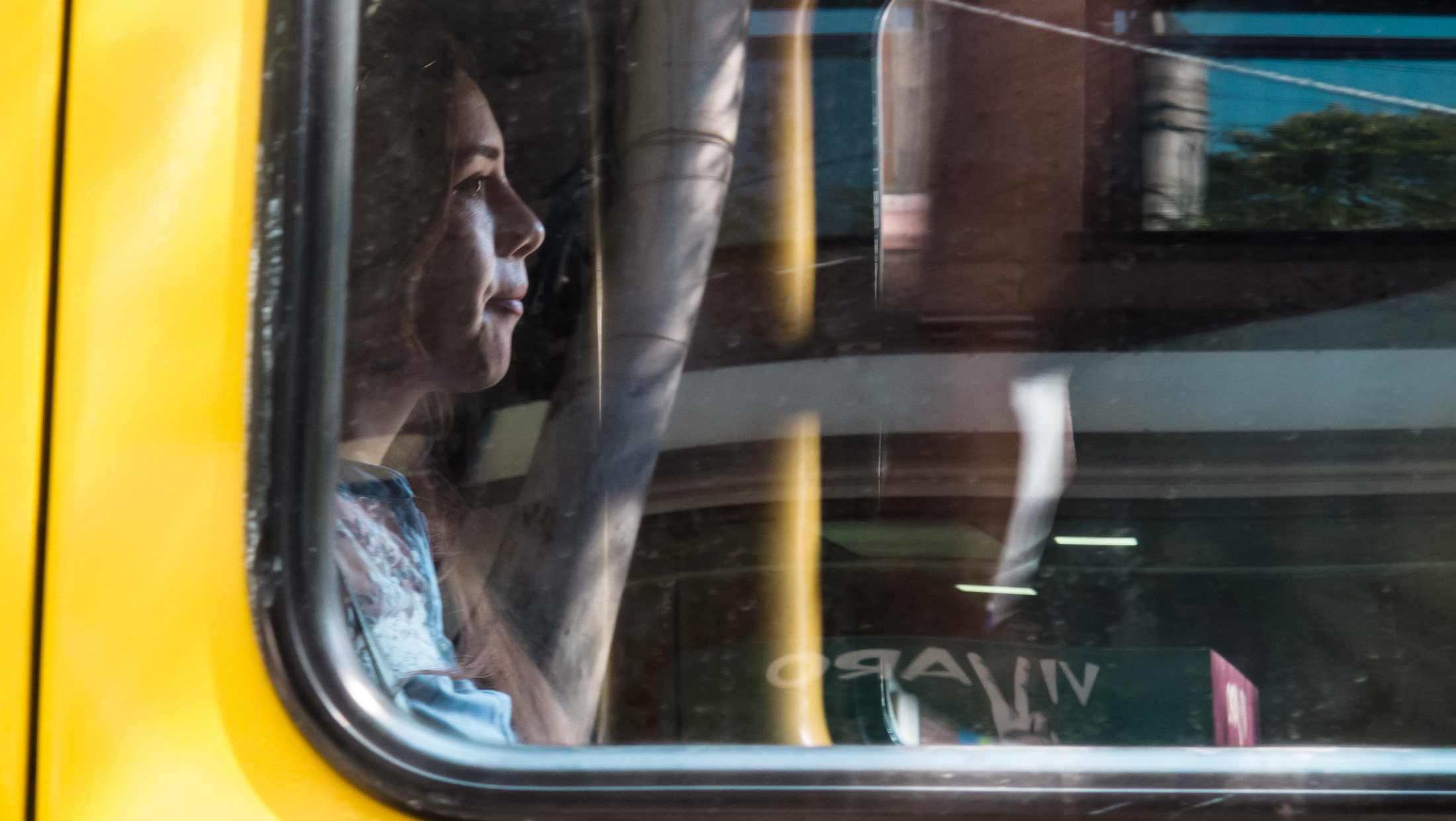 eine melancholisch-blickende junge Frau im Bus